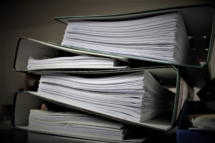Stacked binders full of filed financial records.